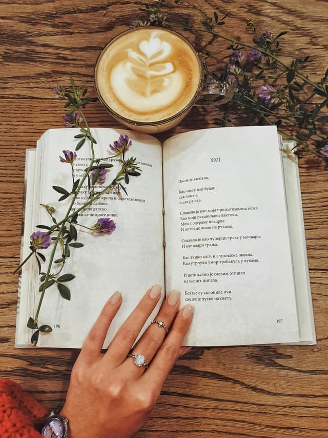 A cozy cup of coffee beside an open book — a quiet creative moment